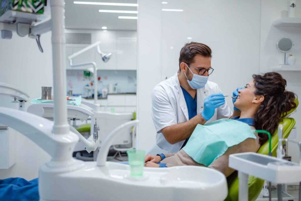 Stock photo of a dentist examining a patient in a dental chair